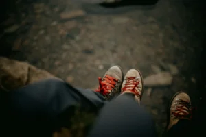 a first person oriented photo, focusing on looking down at hiking boots on their feet