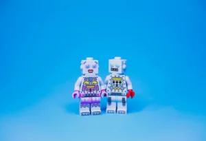 two robot legos on a bright blue background