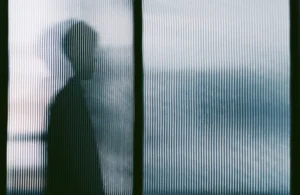 a person's silhouette is seen behind privacy glass