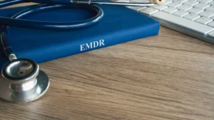 EMDR therapy concept book with medical stethoscope on a desk top next to a computer keyboard