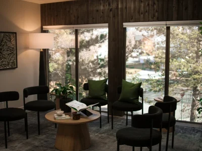A calm waiting room with windows overlooking trees
